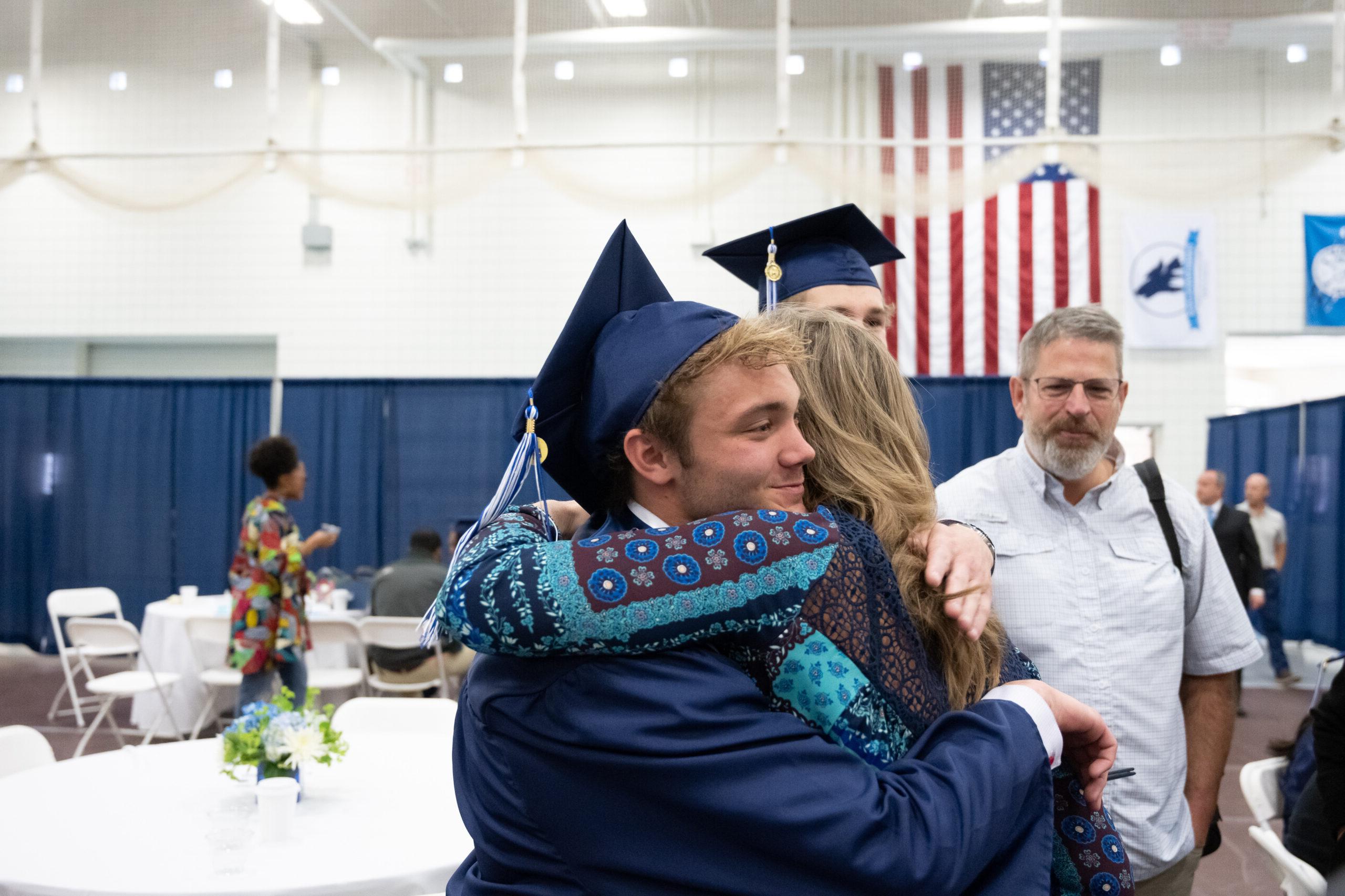 父母在毕业典礼上拥抱他们的学生